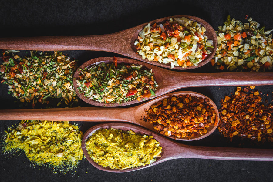 Neutral editorial image of dry spices displayed in wooden spoons